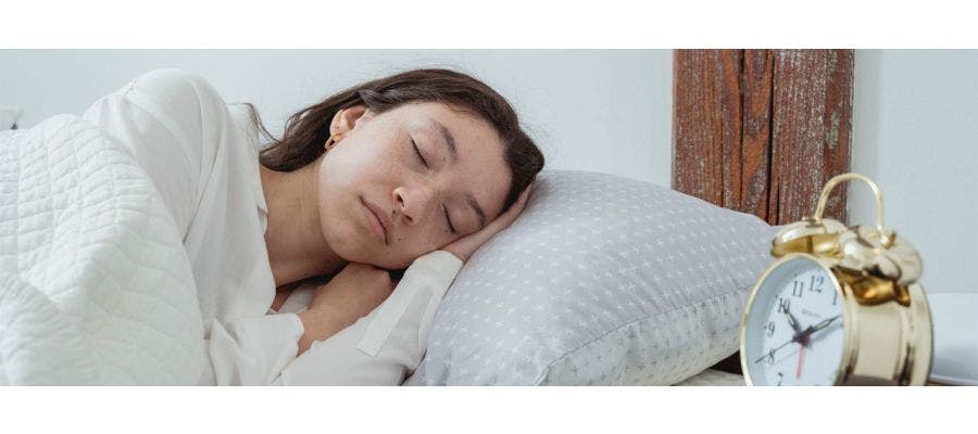 Woman lying on her side in bed, dreaming