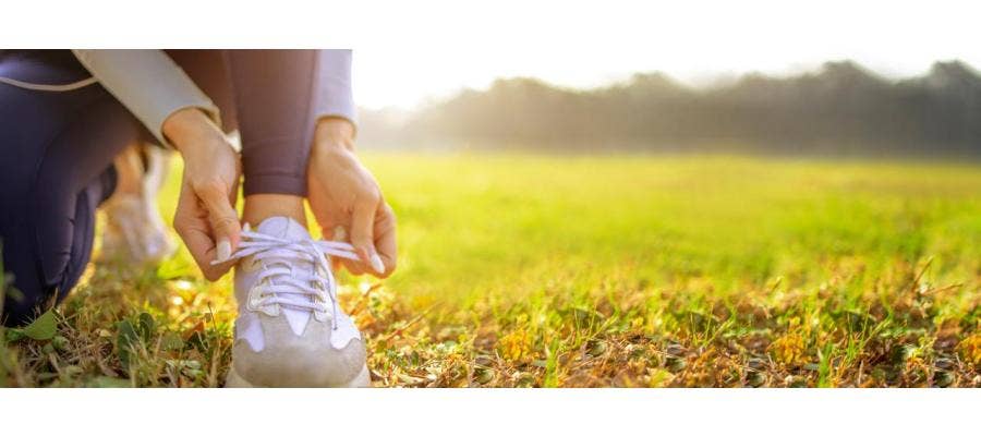 Close-up of a woman's feet as she laces up her walking shoes