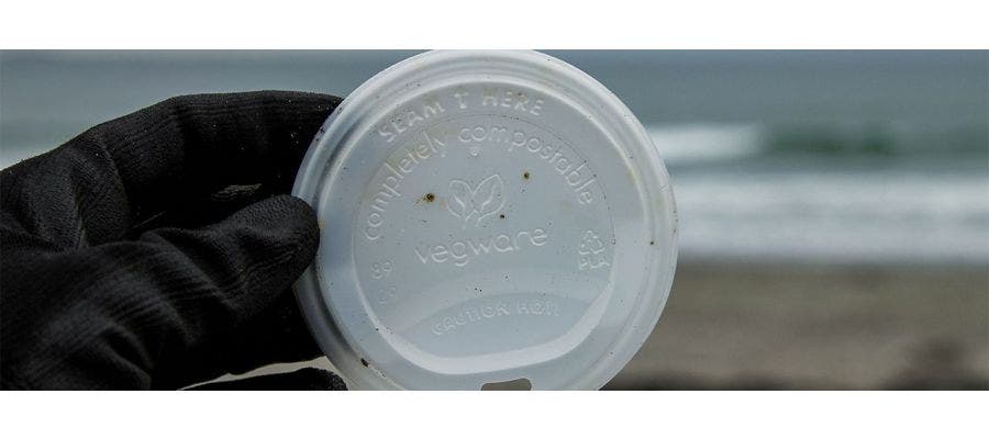 Hand holding a plastic lid from a disposable cup