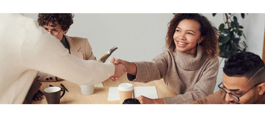 Business owner and customer smiling and shaking hands