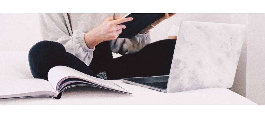 woman on happsy organic mattress reading book with laptop