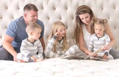 Happy family reading book in bed
