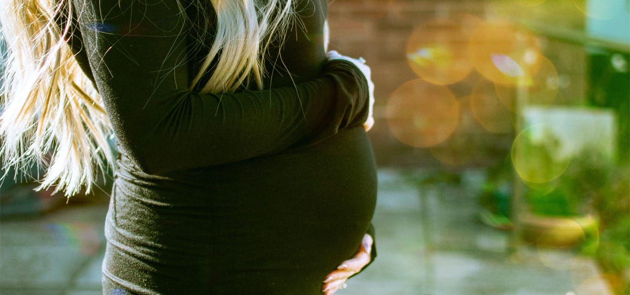 Pregnany woman cradling her belly