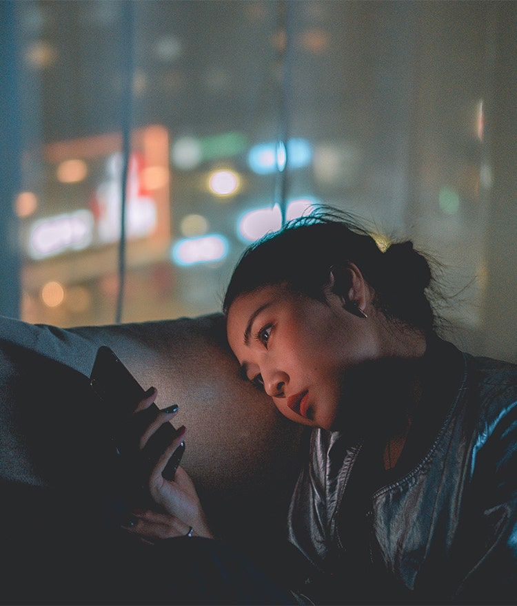 Woman awake late at night, scrolling through her phone