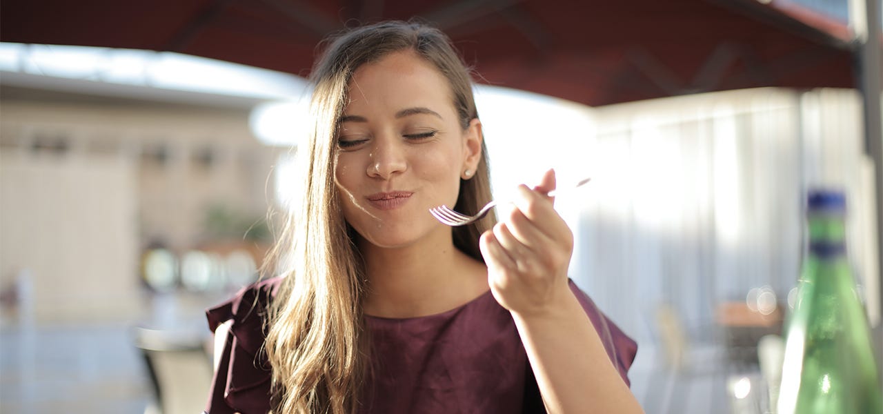 Smiling woman eating lunch outdoors