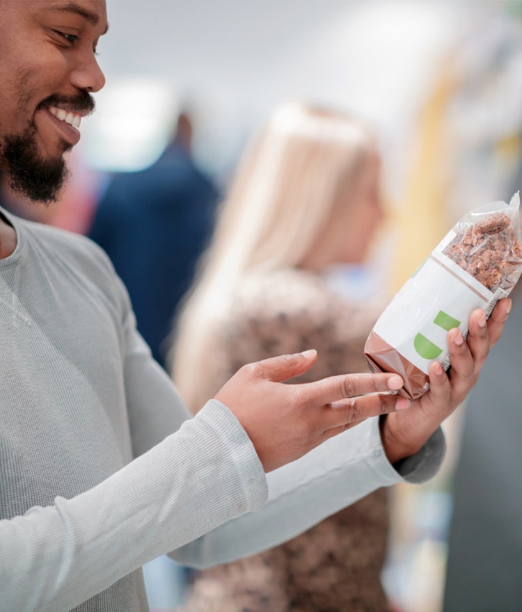 Man at the grocery store picking out organic pasta