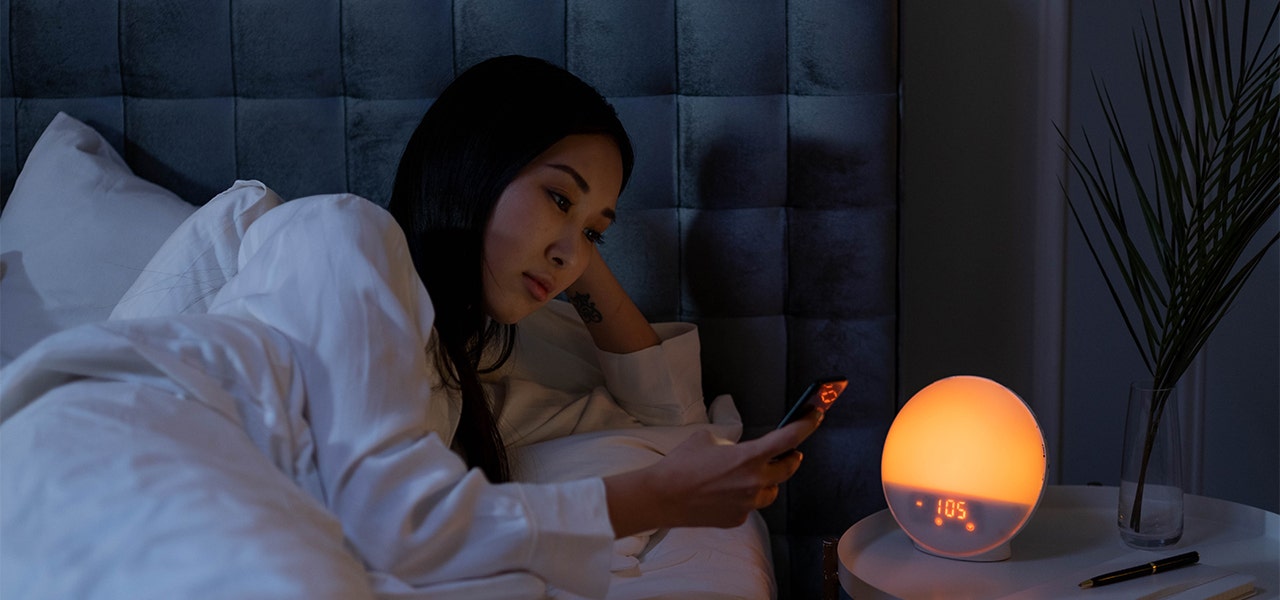 Woman in a darkened bedroom getting ready for bed