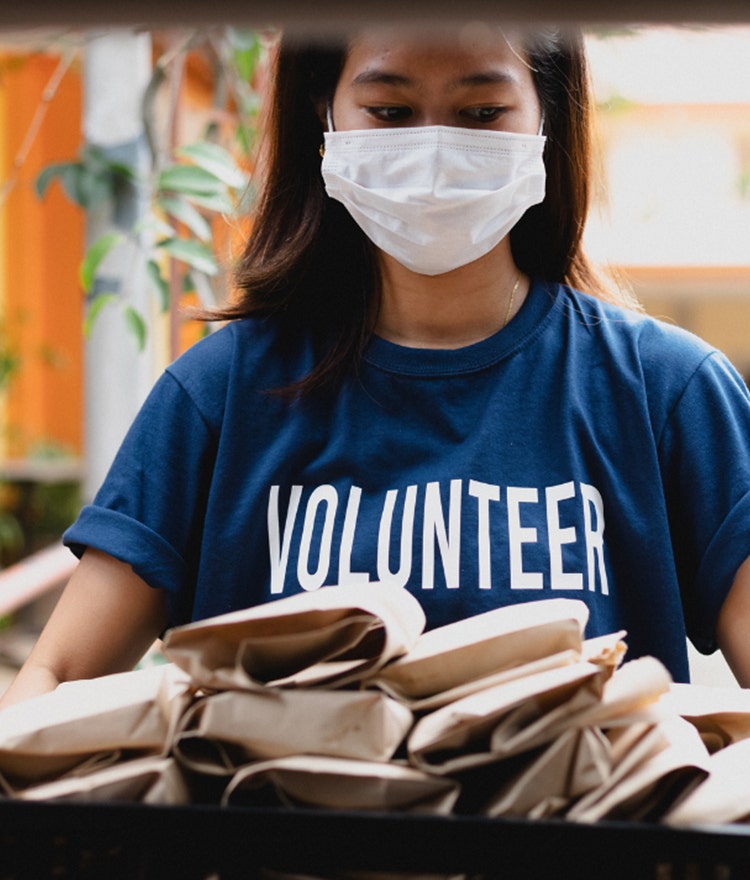 Young woman wearing a mask and a volunteer t-shirt