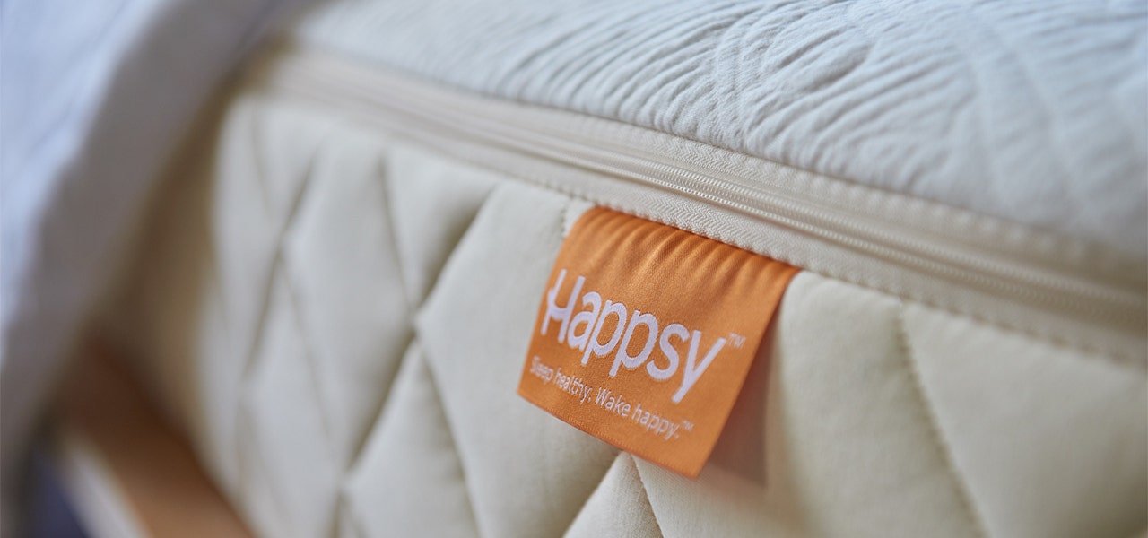 Happsy certified organic mattress with organge branded tag