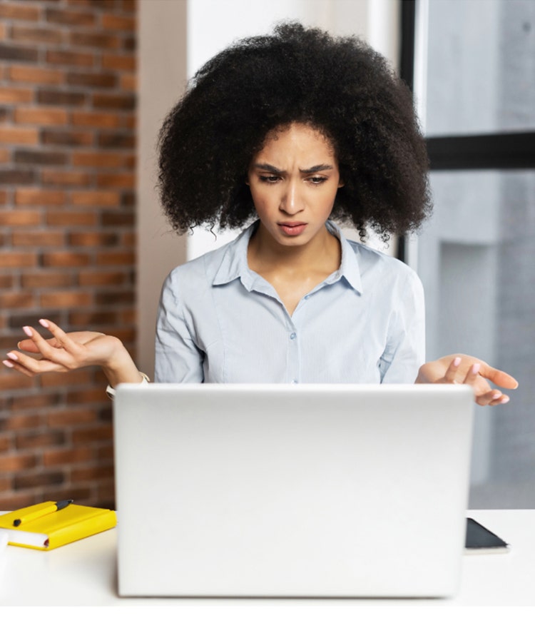 Woman looking confused as she researches mattress off gassing at her laptop