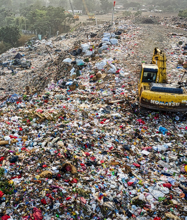 Bulldozer driving over landfill piles