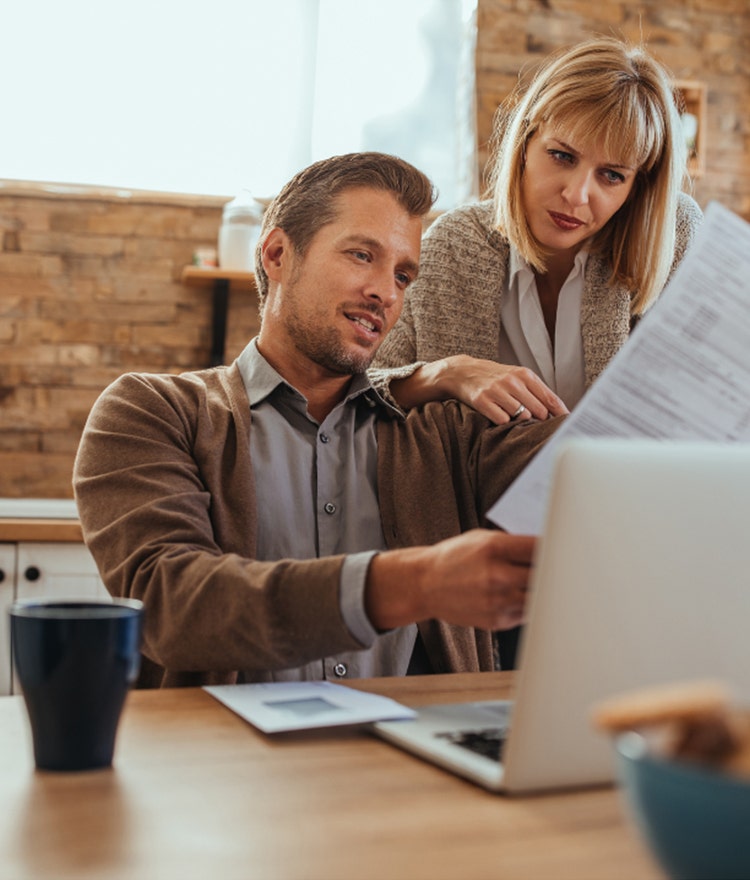 Man and woman looking over their bills and holiday budget