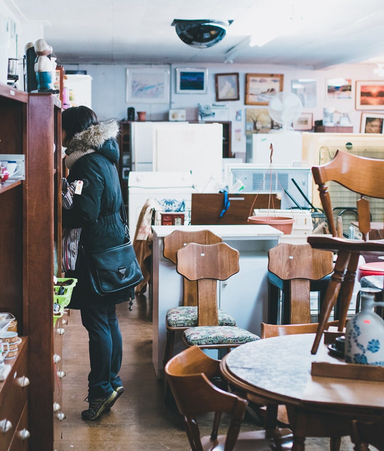 Woman shopping in a thrift store for bedroom decor