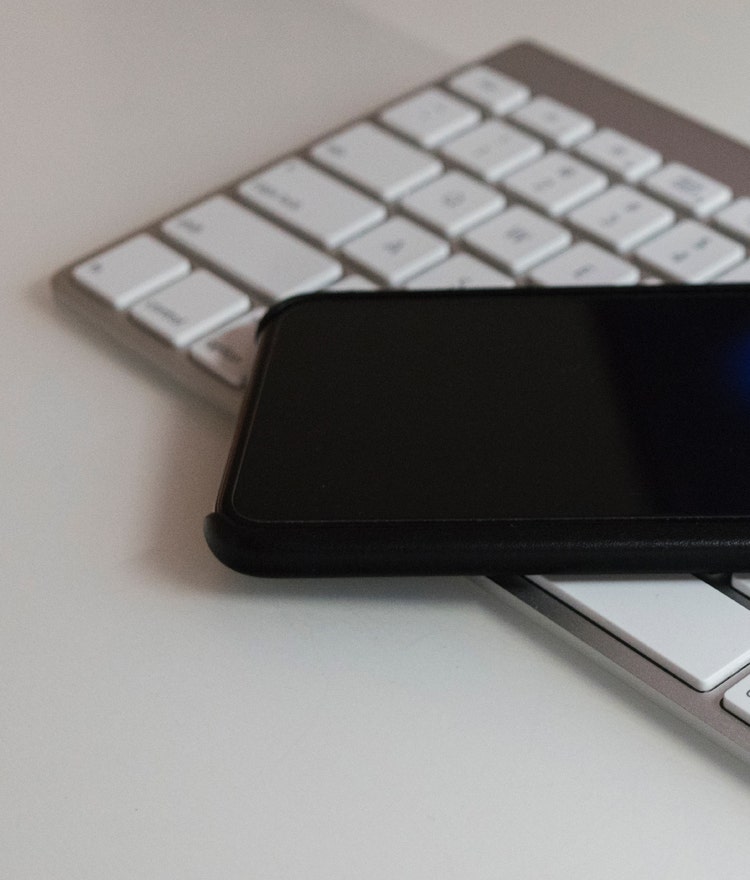 Smartphone laying on top of a wireless keyboard