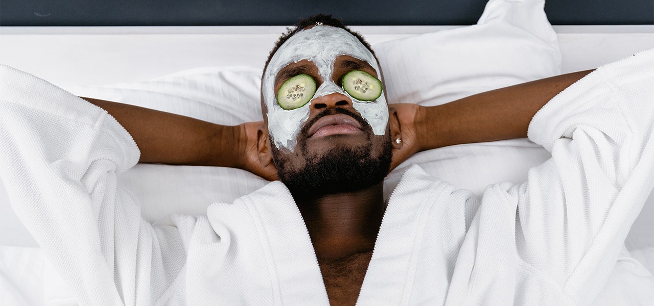 Man in a robe, lying back and enjoying a facial