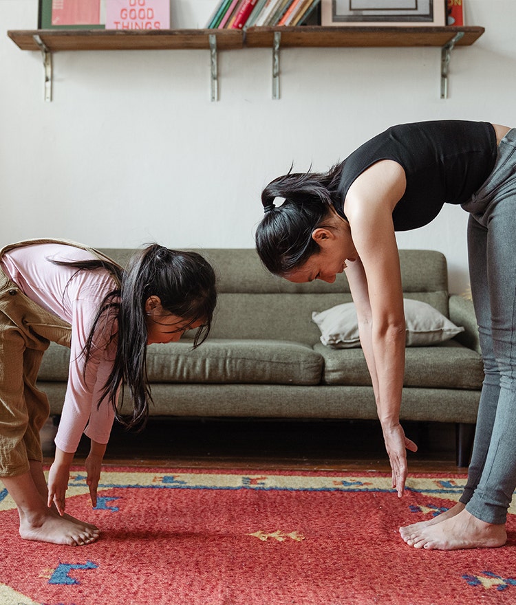 Mother and daughter stretching together as self care