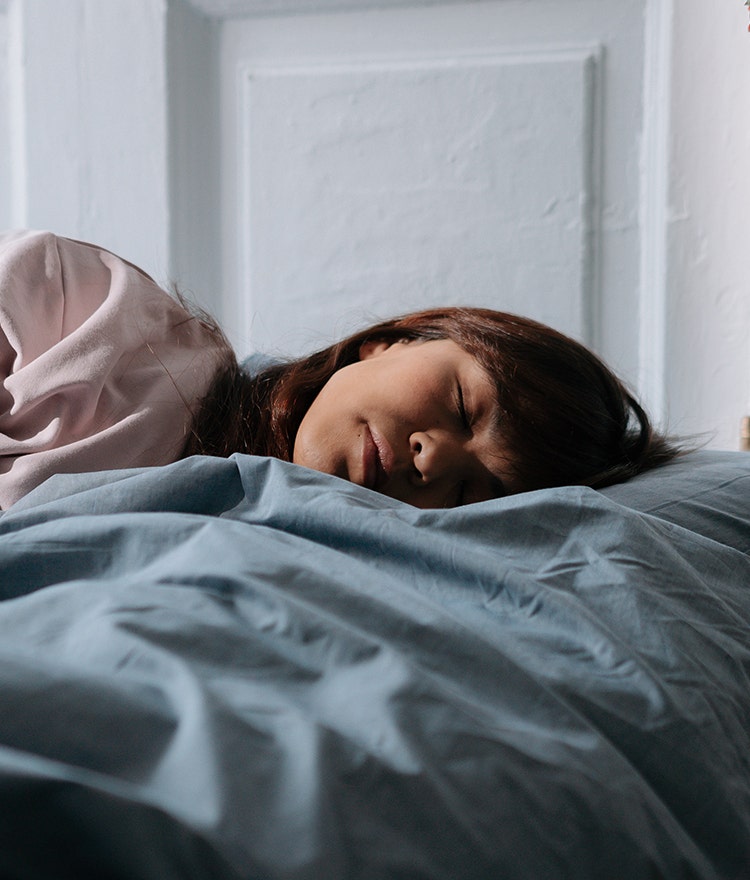 Woman sleeping soundly on her side in bed