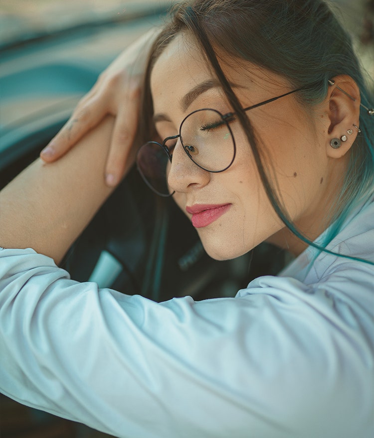 Woman leaning on her steering wheel and resting