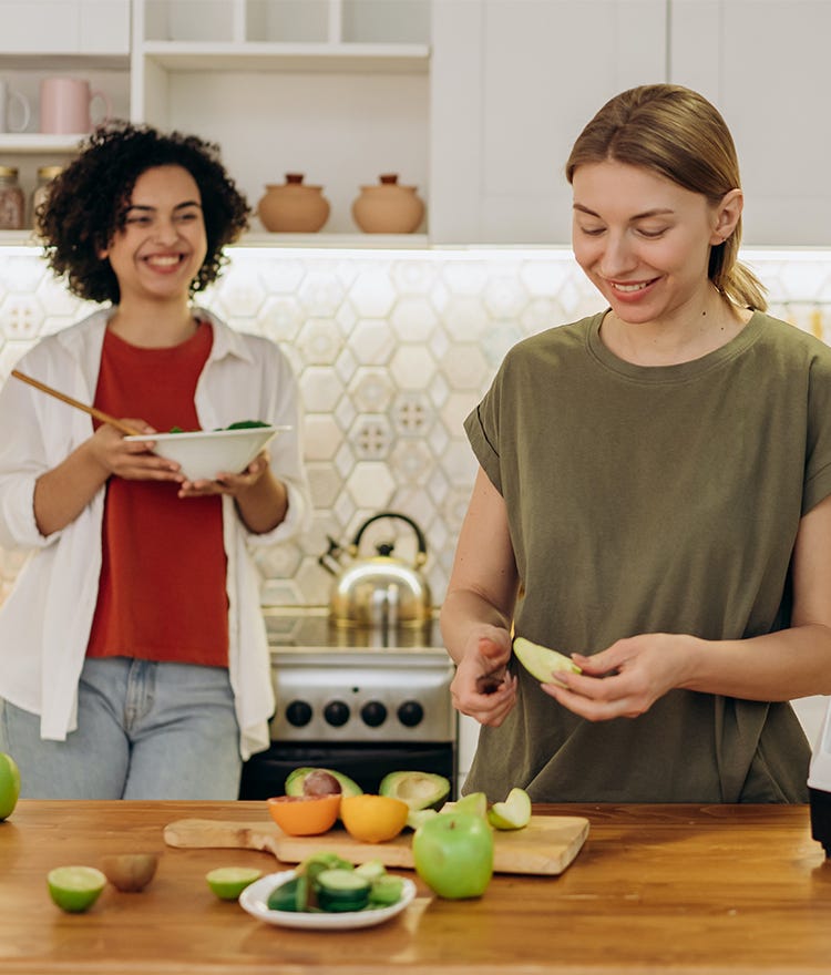 Two friends preparing a meal woth fresh, locally sourced organic food