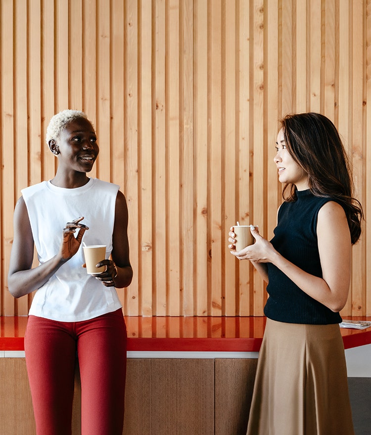 Two women stepping outside to talk over their lunch break