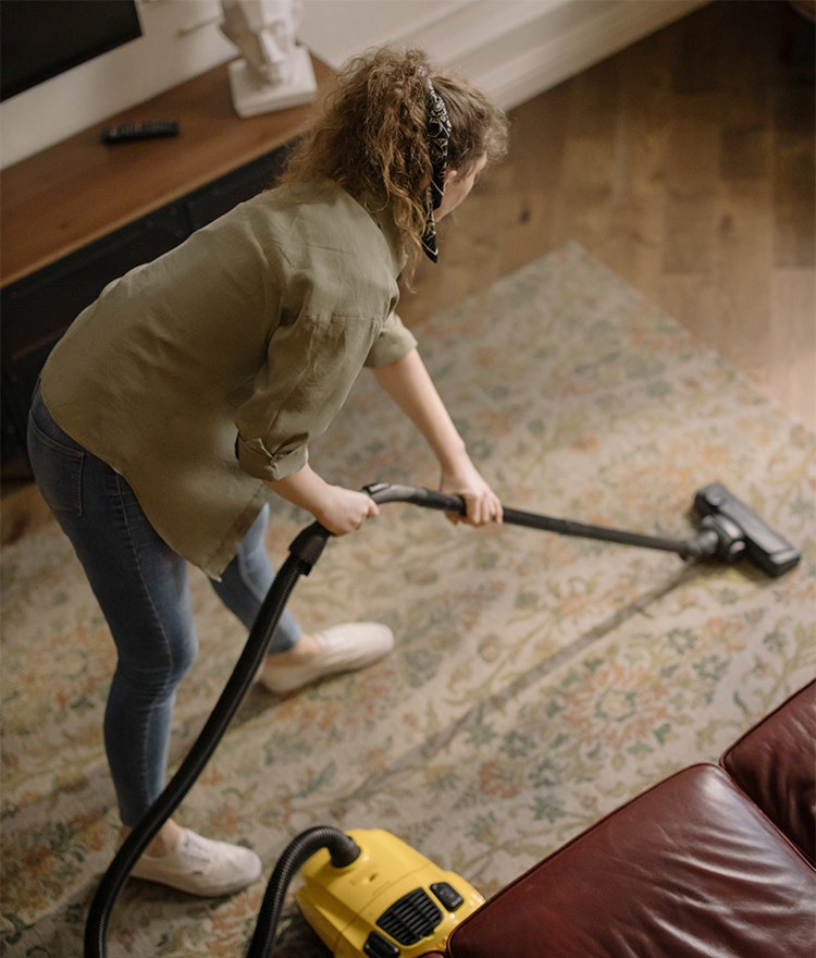 Woman vacuuming as a form of practical self-care