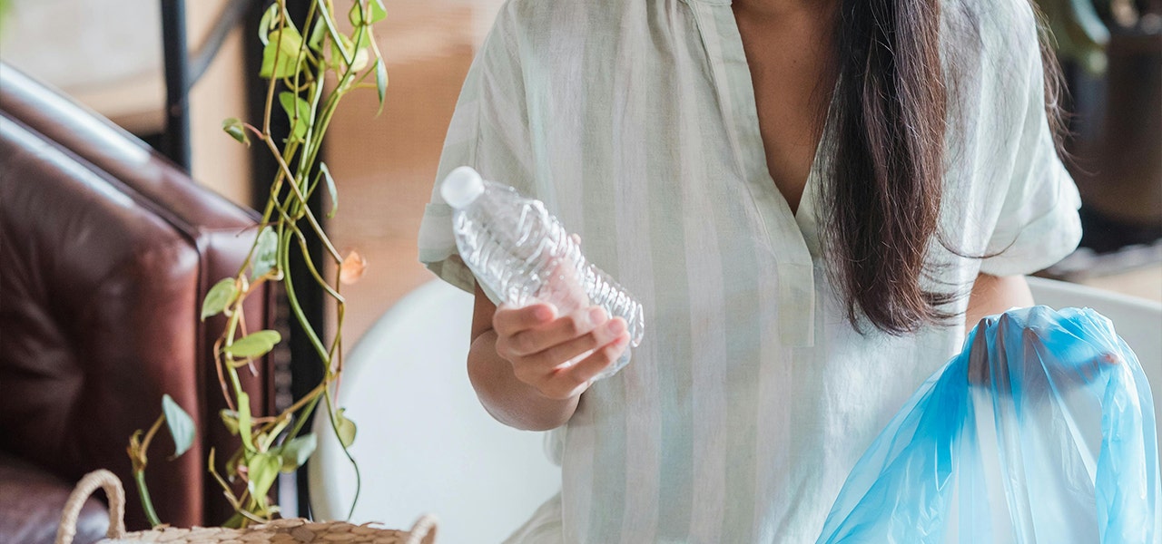 person recycling a water bottle