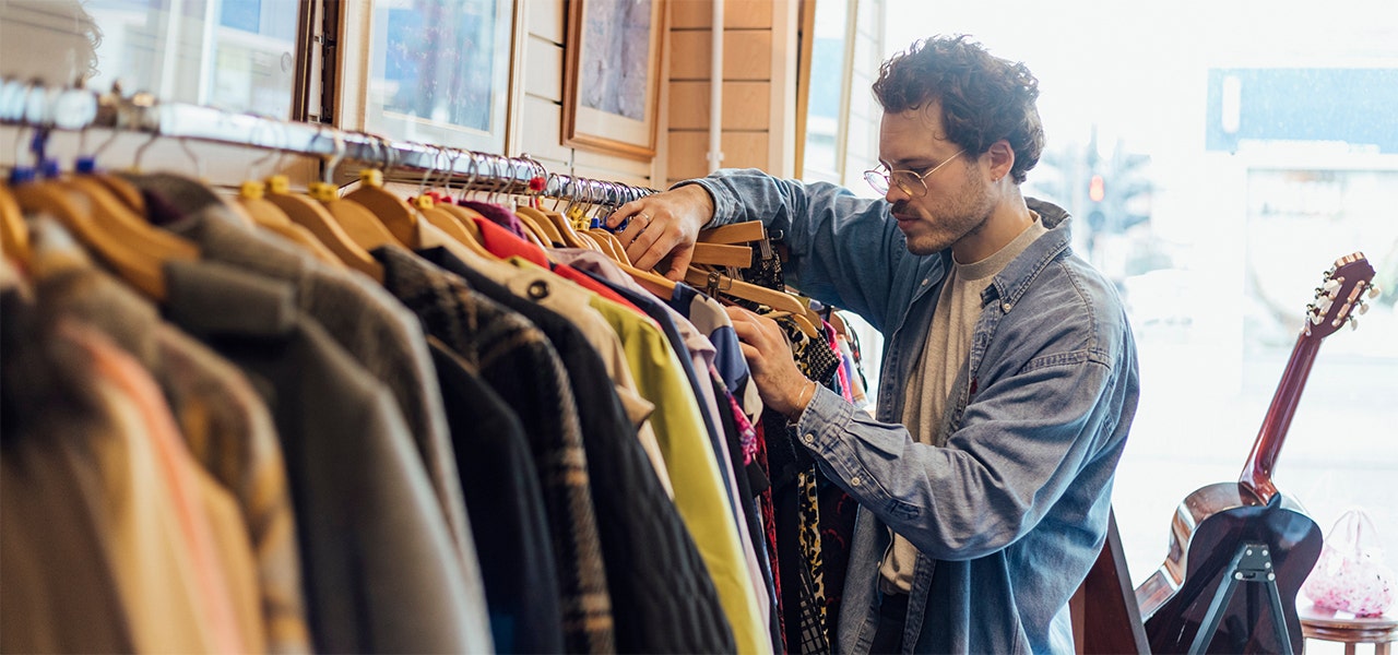 person browsing a clothing rack at a thrift store